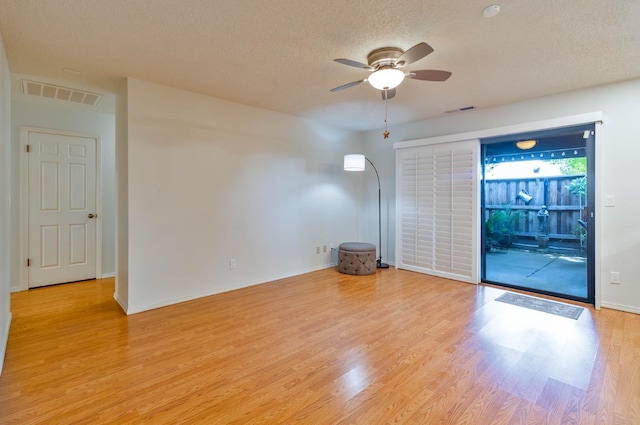 4633 N Glenn Ave, Fresno, CA 93704 - unfurnished room featuring a textured ceiling, light wood-type flooring, a ceiling fan, and baseboards
