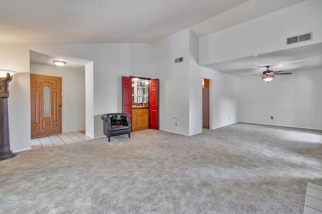 4633 N Glenn Ave, Fresno, CA 93704 - unfurnished living room featuring light carpet, a ceiling fan, a textured ceiling, high vaulted ceiling, and baseboards