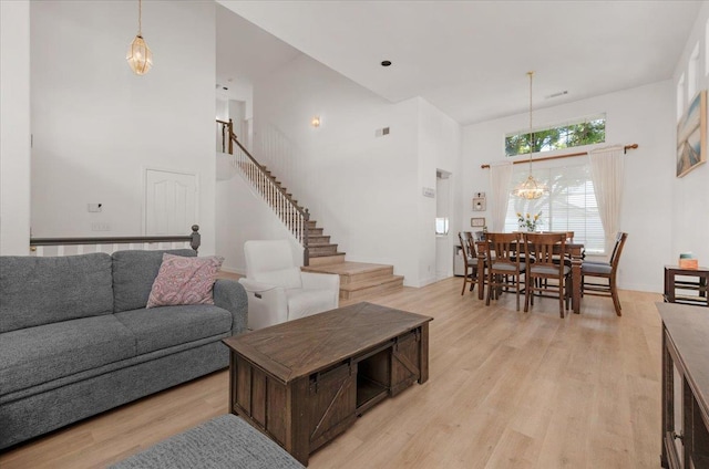 2162 Decatur Ave, Clovis, CA 93611 - living room featuring a towering ceiling, a chandelier, light wood-style floors, and stairway