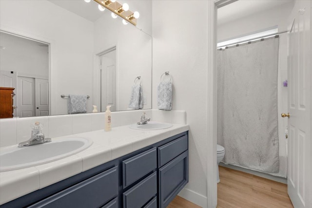 2162 Decatur Ave, Clovis, CA 93611 - bathroom with double vanity, toilet, wood finished floors, and a shower with curtain