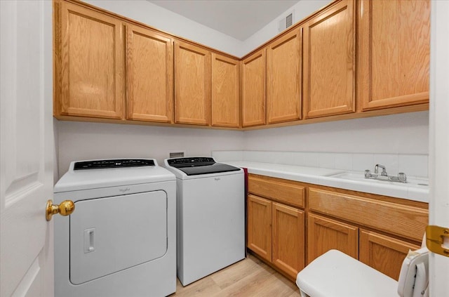 2162 Decatur Ave, Clovis, CA 93611 - washroom featuring cabinet space, washing machine and clothes dryer, and light wood-style flooring