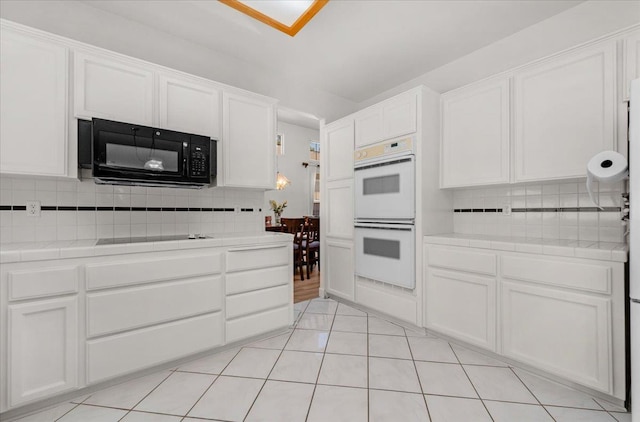 2162 Decatur Ave, Clovis, CA 93611 - kitchen with black appliances, tile countertops, tasteful backsplash, and white cabinetry