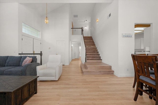 2162 Decatur Ave, Clovis, CA 93611 - living room featuring a towering ceiling, stairs, baseboards, and light wood-type flooring