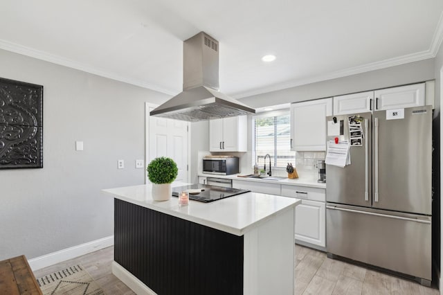 1583 San Gabriel Ave, Clovis, CA 93611 - kitchen featuring stainless steel appliances, island range hood, a sink, light wood-style floors, and white cabinets