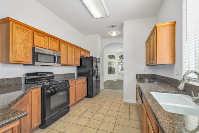 6674 E Alta Ave, Fresno, CA 93727 - kitchen featuring black appliances, a sink, arched walkways, light tile patterned floors, and healthy amount of natural light
