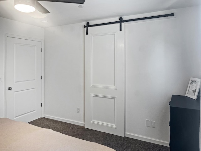 922 Winchell Way W, Madera, CA 93636 - unfurnished bedroom with dark carpet, a barn door, baseboards, and ceiling fan