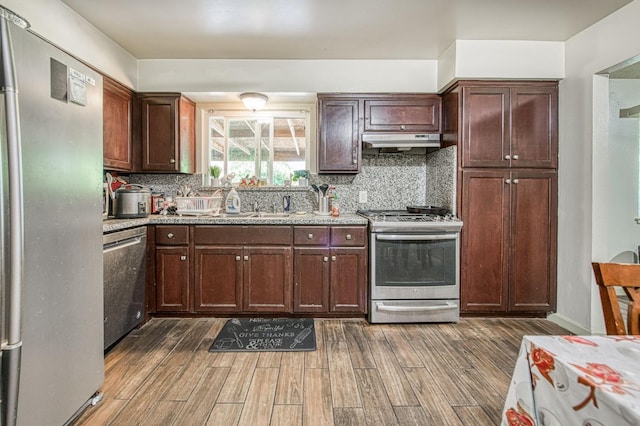1431 N Willow Ave, Fresno, CA 93727 - kitchen with stainless steel appliances, under cabinet range hood, wood finished floors, tasteful backsplash, and light stone countertops