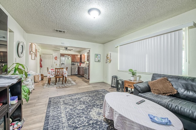 1431 N Willow Ave, Fresno, CA 93727 - living room with light wood finished floors, a textured ceiling, and ceiling fan