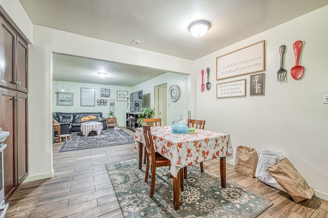 1431 N Willow Ave, Fresno, CA 93727 - dining area with wood finished floors, baseboards, and a textured ceiling