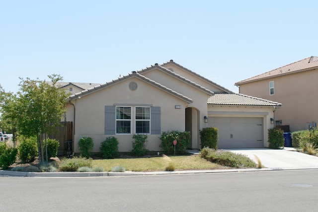 6379 W Northdale Ave, Fresno, CA 93723 - mediterranean / spanish-style home with an attached garage, concrete driveway, stucco siding, and a tiled roof