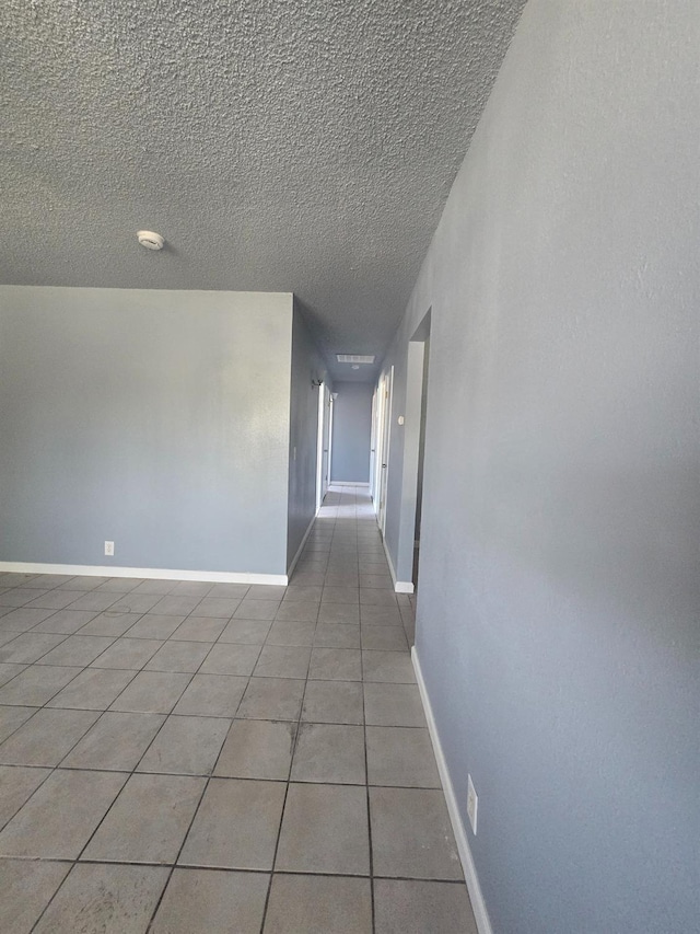 924 W Myers, Fresno, CA 93706 - empty room featuring light tile patterned flooring, a textured ceiling, baseboards, and a smoke detector