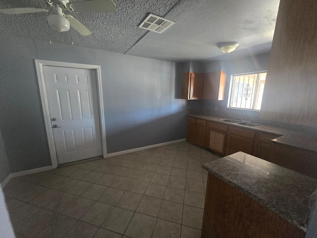 924 W Myers, Fresno, CA 93706 - kitchen with a sink, baseboards, ceiling fan, a textured ceiling, and light tile patterned flooring