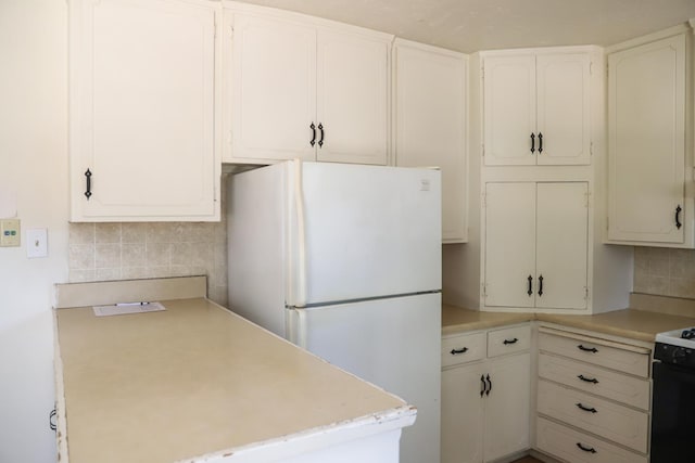 1020 E Saginaw Way, Fresno, CA 93704 - kitchen with freestanding refrigerator, light countertops, decorative backsplash, black range with electric stovetop, and white cabinets