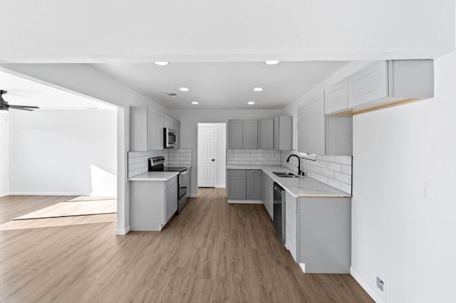 3877 N Ezie, Fresno, CA 93727 - kitchen featuring stainless steel appliances, gray cabinetry, light countertops, a sink, and light wood-style floors
