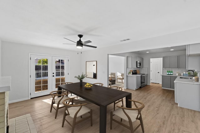 3877 N Ezie, Fresno, CA 93727 - dining room with light wood-type flooring, french doors, ceiling fan, baseboards, and a fireplace