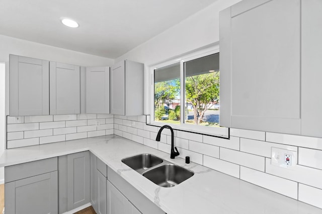 3877 N Ezie, Fresno, CA 93727 - kitchen with a sink, gray cabinets, backsplash, light stone countertops, and recessed lighting