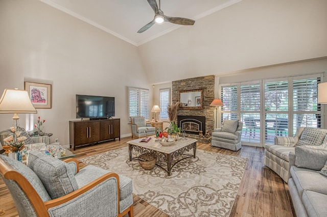 6772 N Wembley Dr, Fresno, CA 93711 - living area with high vaulted ceiling, plenty of natural light, a ceiling fan, a stone fireplace, and wood finished floors