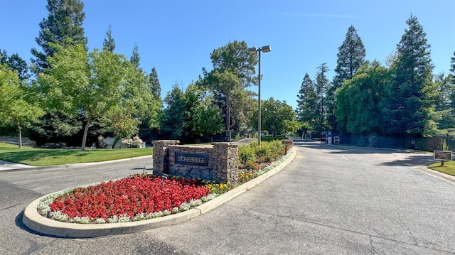 6772 N Wembley Dr, Fresno, CA 93711 - view of asphalt road featuring curbs and a gated entry