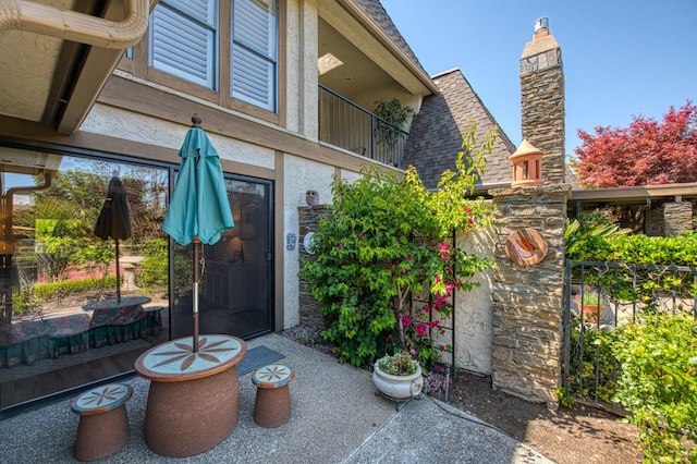 6772 N Wembley Dr, Fresno, CA 93711 - doorway to property featuring stucco siding and a chimney