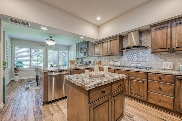 6772 N Wembley Dr, Fresno, CA 93711 - kitchen with appliances with stainless steel finishes, wall chimney range hood, light wood-type flooring, backsplash, and a center island