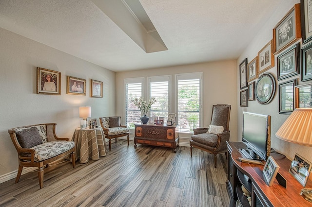 6772 N Wembley Dr, Fresno, CA 93711 - living area with wood finished floors, baseboards, and a textured ceiling