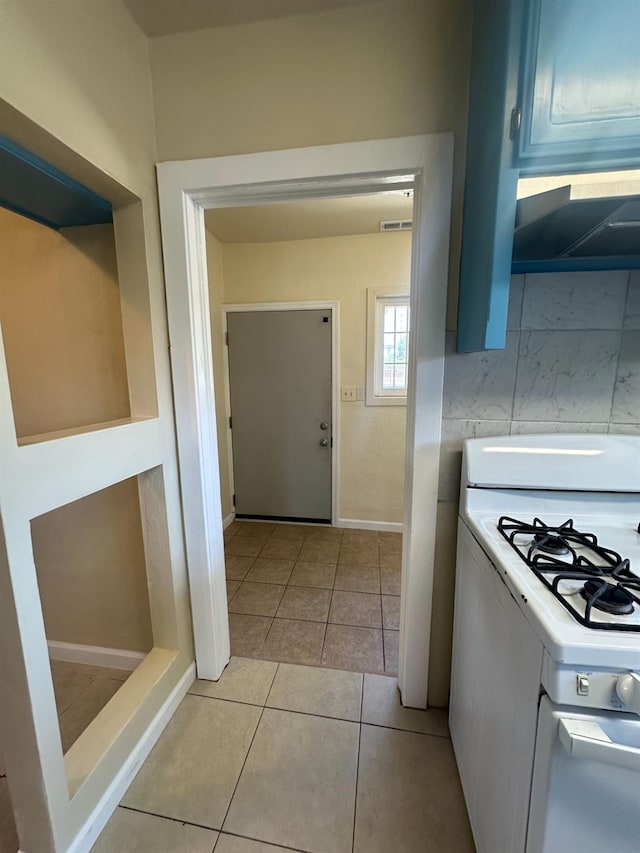 3023 E White Ave, Fresno, CA 93701 - kitchen with white range with gas stovetop, light tile patterned flooring, light countertops, extractor fan, and baseboards