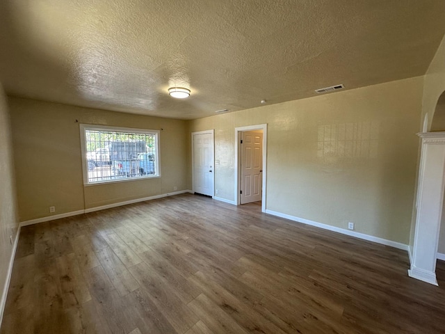 3023 E White Ave, Fresno, CA 93701 - unfurnished room featuring dark wood finished floors, a textured ceiling, and baseboards