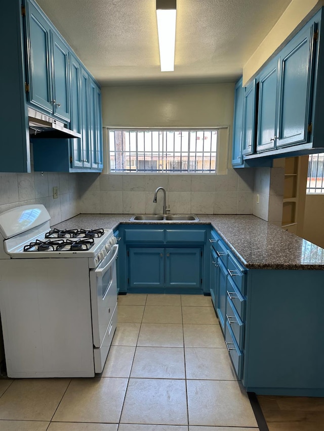 3023 E White Ave, Fresno, CA 93701 - kitchen featuring white range with gas cooktop, blue cabinets, under cabinet range hood, a sink, and a textured ceiling