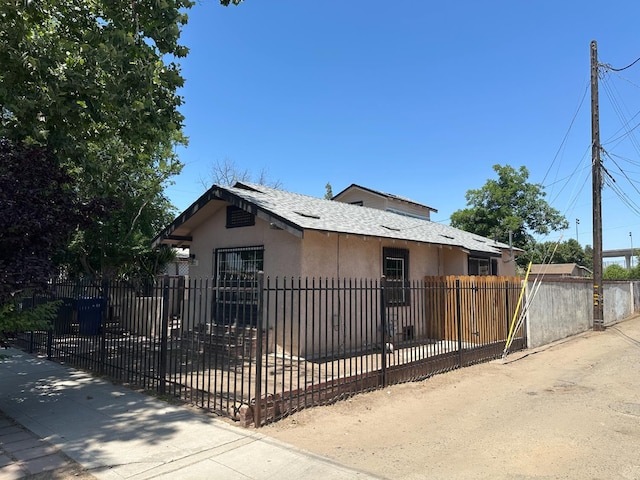 3023 E White Ave, Fresno, CA 93701 - bungalow with stucco siding, a fenced front yard, and roof with shingles