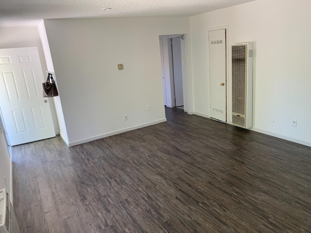 3127 E Mckenzie, Fresno, CA 93702 - spare room featuring a heating unit, dark wood-style flooring, baseboards, and a textured ceiling