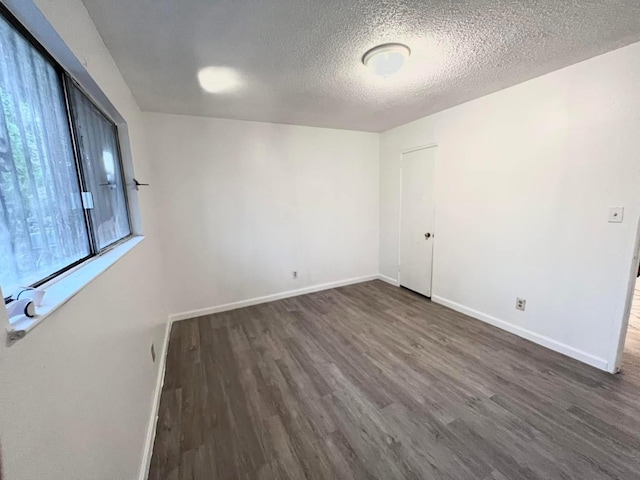 3127 E Mckenzie, Fresno, CA 93702 - unfurnished room featuring dark wood finished floors, a textured ceiling, and baseboards