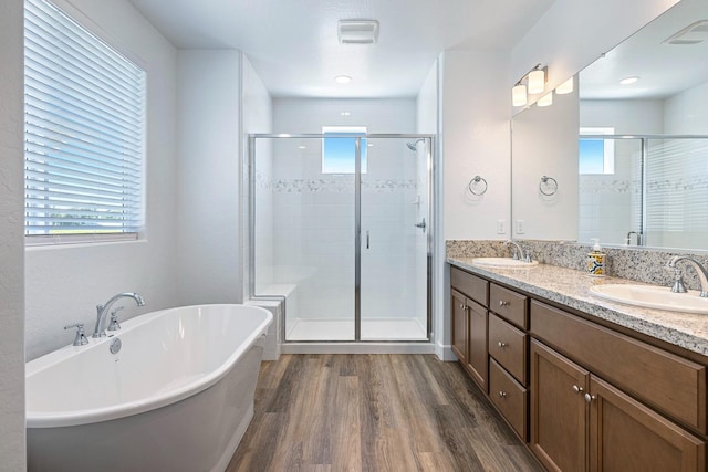 2054 N Laverne Ave, Fresno, CA 93727 - full bath featuring wood finished floors, a freestanding tub, a stall shower, and double vanity