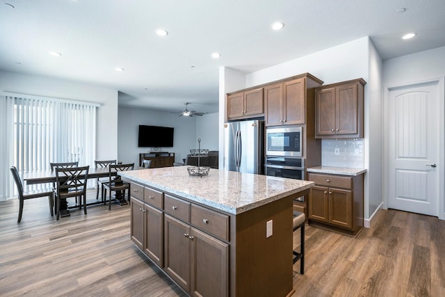 2054 N Laverne Ave, Fresno, CA 93727 - kitchen with appliances with stainless steel finishes, a center island, light wood-style flooring, a ceiling fan, and recessed lighting