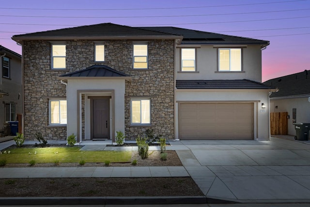 2054 N Laverne Ave, Fresno, CA 93727 - view of front of home featuring concrete driveway, stone siding, an attached garage, solar panels, and stucco siding
