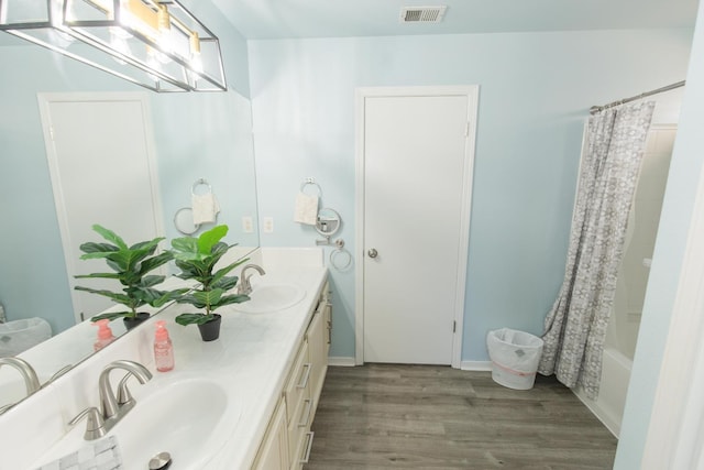 6412 E Inyo St, Fresno, CA 93727 - full bathroom with double vanity, wood finished floors, and shower / tub combo