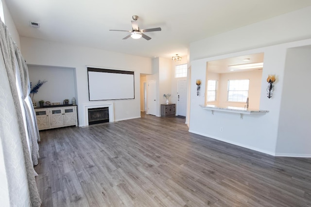 6412 E Inyo St, Fresno, CA 93727 - home theater room with wood finished floors, ceiling fan, a fireplace, and baseboards