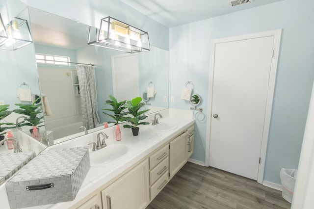 6412 E Inyo St, Fresno, CA 93727 - full bathroom featuring double vanity, wood finished floors, and shower / bathtub combination with curtain