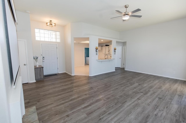 6412 E Inyo St, Fresno, CA 93727 - unfurnished living room with dark wood-type flooring, a ceiling fan, a chandelier, a sink, and baseboards