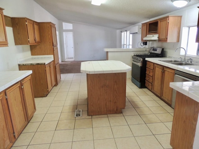 15716 S Hughes, Caruthers, CA 93609 - kitchen featuring appliances with stainless steel finishes, under cabinet range hood, healthy amount of natural light, light tile patterned floors, and a textured ceiling