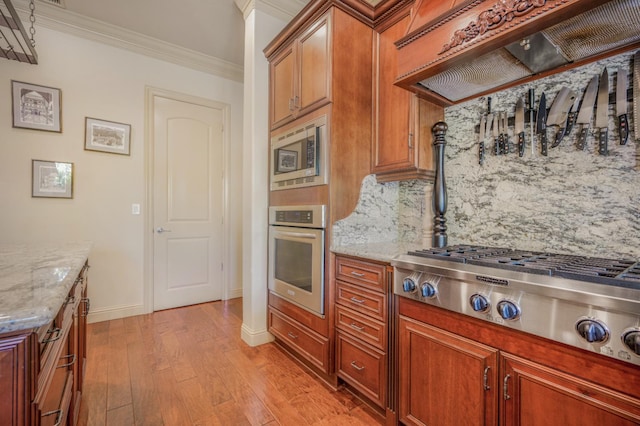 2136 E Royal Dornoch Ave, Fresno, CA 93730 - kitchen featuring appliances with stainless steel finishes, custom exhaust hood, decorative backsplash, light wood-type flooring, and baseboards