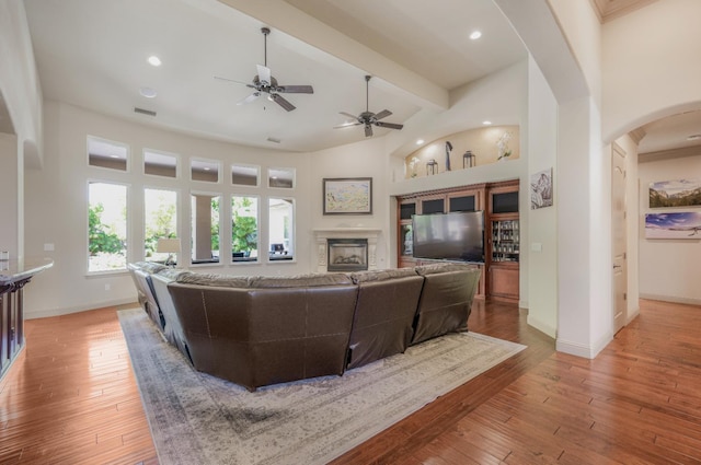 2136 E Royal Dornoch Ave, Fresno, CA 93730 - living room with arched walkways, baseboards, light wood-style flooring, ceiling fan, and beamed ceiling