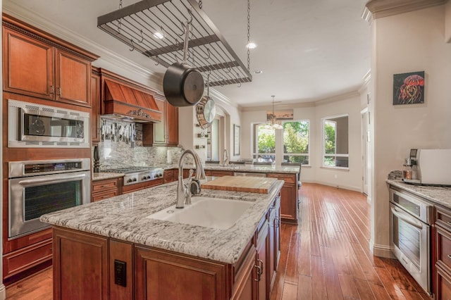2136 E Royal Dornoch Ave, Fresno, CA 93730 - kitchen with appliances with stainless steel finishes, a sink, crown molding, baseboards, and an island with sink