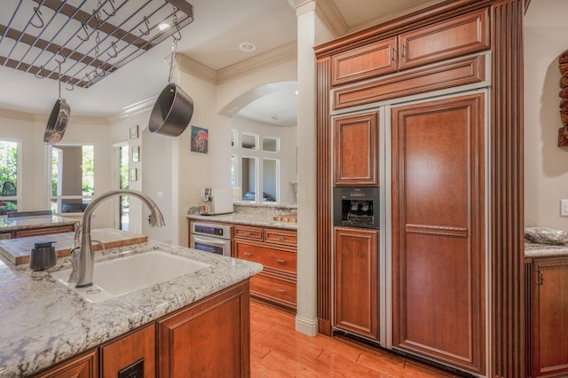 2136 E Royal Dornoch Ave, Fresno, CA 93730 - kitchen featuring a sink, paneled built in refrigerator, light wood-style flooring, crown molding, and light stone counters