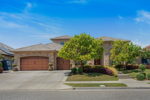 2136 E Royal Dornoch Ave, Fresno, CA 93730 - view of front of home featuring an attached garage, concrete driveway, a tile roof, stone siding, and a front yard