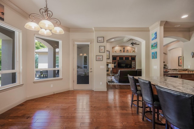 2136 E Royal Dornoch Ave, Fresno, CA 93730 - dining area featuring arched walkways, ornamental molding, dark wood-type flooring, a chandelier, and ceiling fan