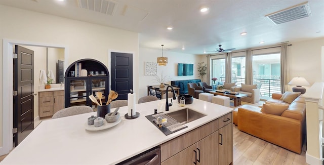 2897 E Tamarind Dr, Fresno, CA 93730 - kitchen with a sink, open floor plan, light countertops, light wood finished floors, and ceiling fan
