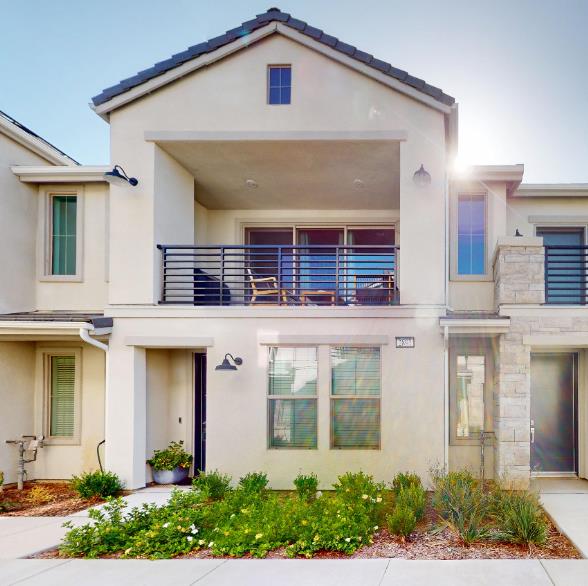 2897 E Tamarind Dr, Fresno, CA 93730 - view of front of house with a balcony, stucco siding, and stone siding