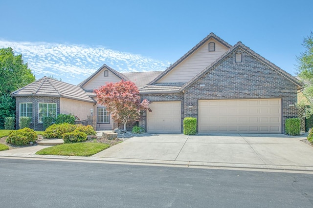 1251 E Rosemont Ln, Fresno, CA 93730 - view of front of home with a garage, driveway, a tile roof, and brick siding