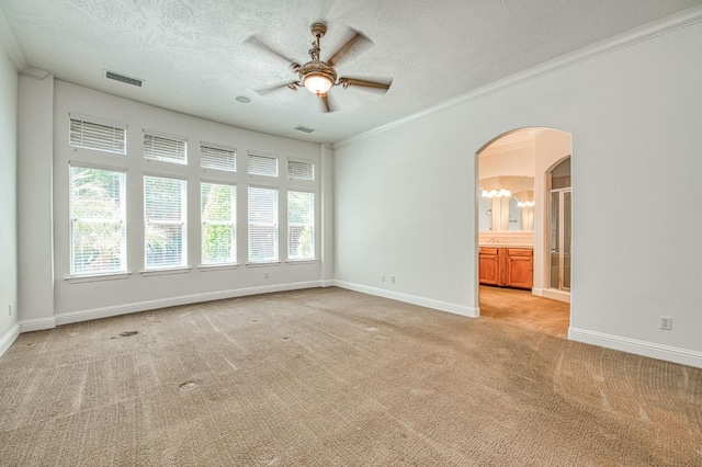 1251 E Rosemont Ln, Fresno, CA 93730 - spare room featuring arched walkways, ceiling fan, light carpet, a textured ceiling, and crown molding