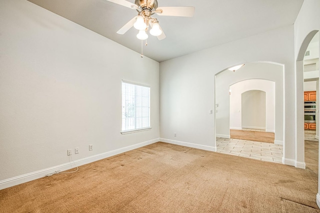 1251 E Rosemont Ln, Fresno, CA 93730 - unfurnished room with carpet floors, arched walkways, ceiling fan, baseboards, and vaulted ceiling